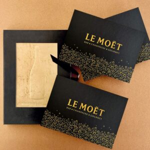 Exklusive Eventeinladung mit Gold-Folienprägung als schwarze Klappkarte zu einem Champagner-Event