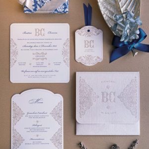 Elegante Hochzeitseinladung im »Winterwonderland« Stil, mit Rosé Pockethülle und Holzprägung. In der Hülle stecken schneeweiße Letterpress Einladungskarten in Zartrosa und und in blau bedruckt. Die Menükarten sind geformt