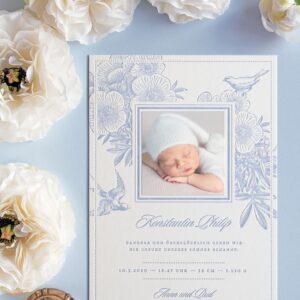 Letterpress Geburtsanzeige für Buben mit blau bedruckten Blüten, einem Vogelpaar und einem aufgeklebtem Babyfoto.