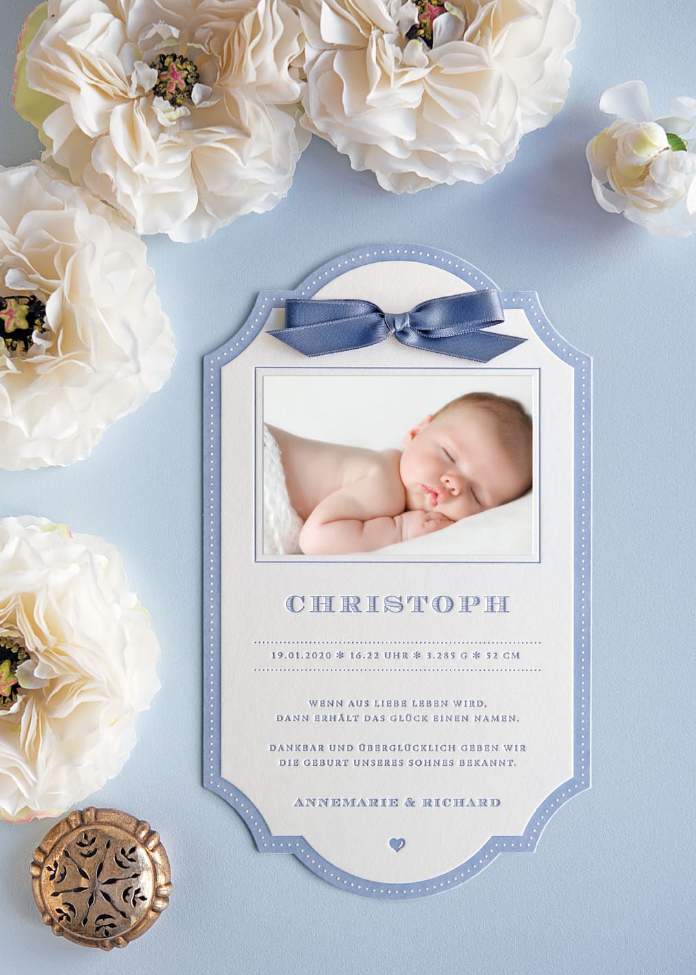Stilvolle Geburtskarte im Letterpress auf Form gestanzt, in RAuchblau bedruckt, mit einem Baby-Foto und einer Satinschleife in Rauchblau geschmückt
