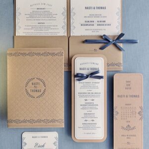 Letterpress Hochzeitseinladungen »Pocketfold« mit bedruckter Hülle im floralen Design und Punktelinien-Rahmen auf Natur-Karton. In der Hülle stecken verschiedene Einlegekarten, die in Rauchblau bedruckt sind.