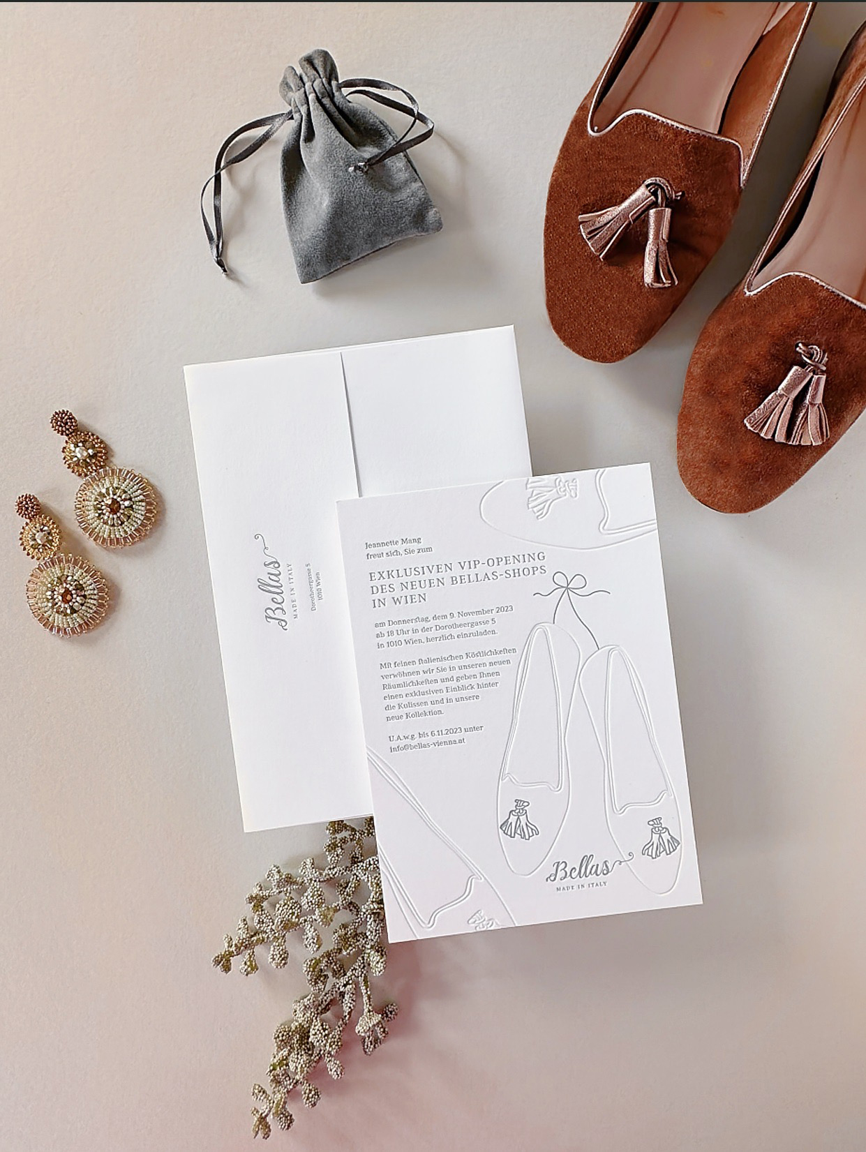 Weiße Letterpress Eventeinladung in grau bedruckt und farblos geprägt zur Shoperöffnung von »Bellas Made in Italy« Schuhe mit Tasseln